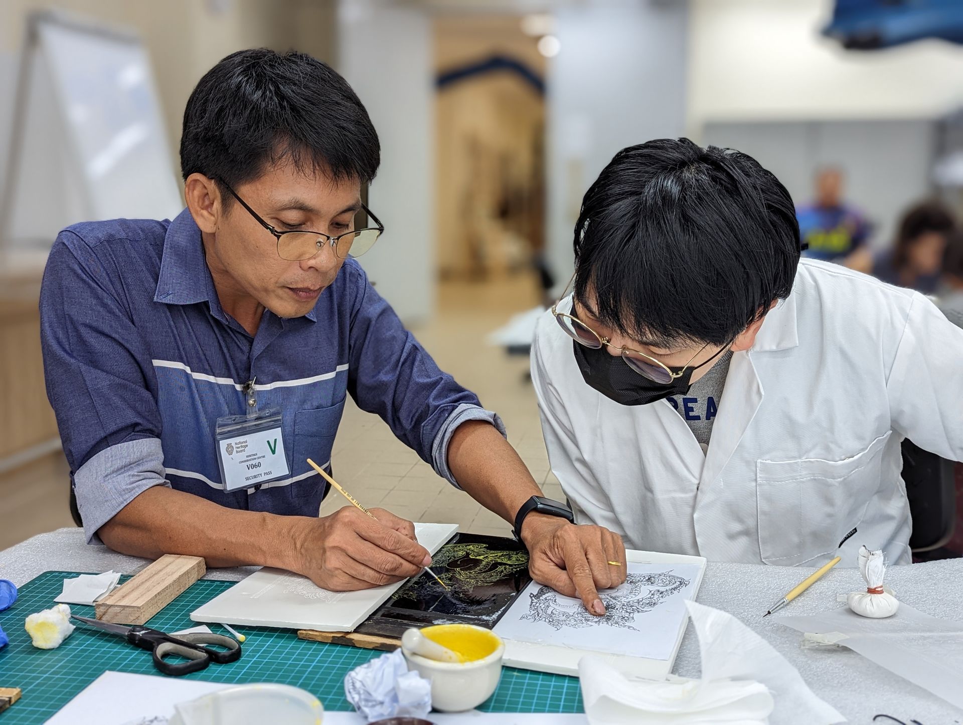 Phumrapee Kongrit (left) guiding Leon Sim (right), Assistant Objects Conservator, on the Lai Rod Nam technique. Image courtesy of Jingyi Zhang. 