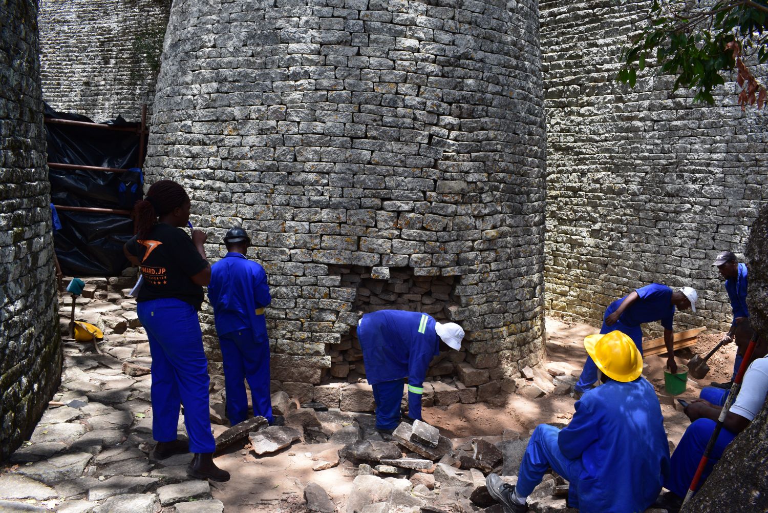 Stonemasons and the Great Zimbabwe conservation team restoring the Conical Tower in the Great Enclosure, 2016. Image by Munyaradzi Elton Sagiya. 
