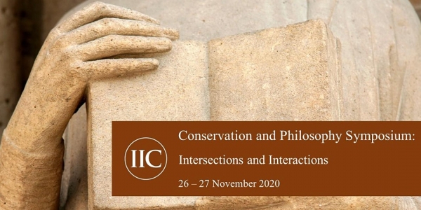 stone carved image of  hand holding book along with symposium title and date