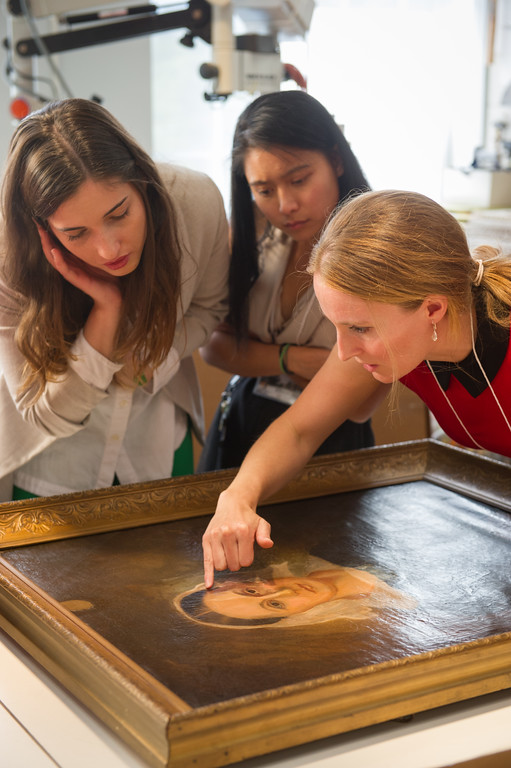 A group of Buffalo art conservation students examining a painting during a recent Art Conservation Clinic. Photograph by Bruce Fox. Image courtesy of Buffalo State University.